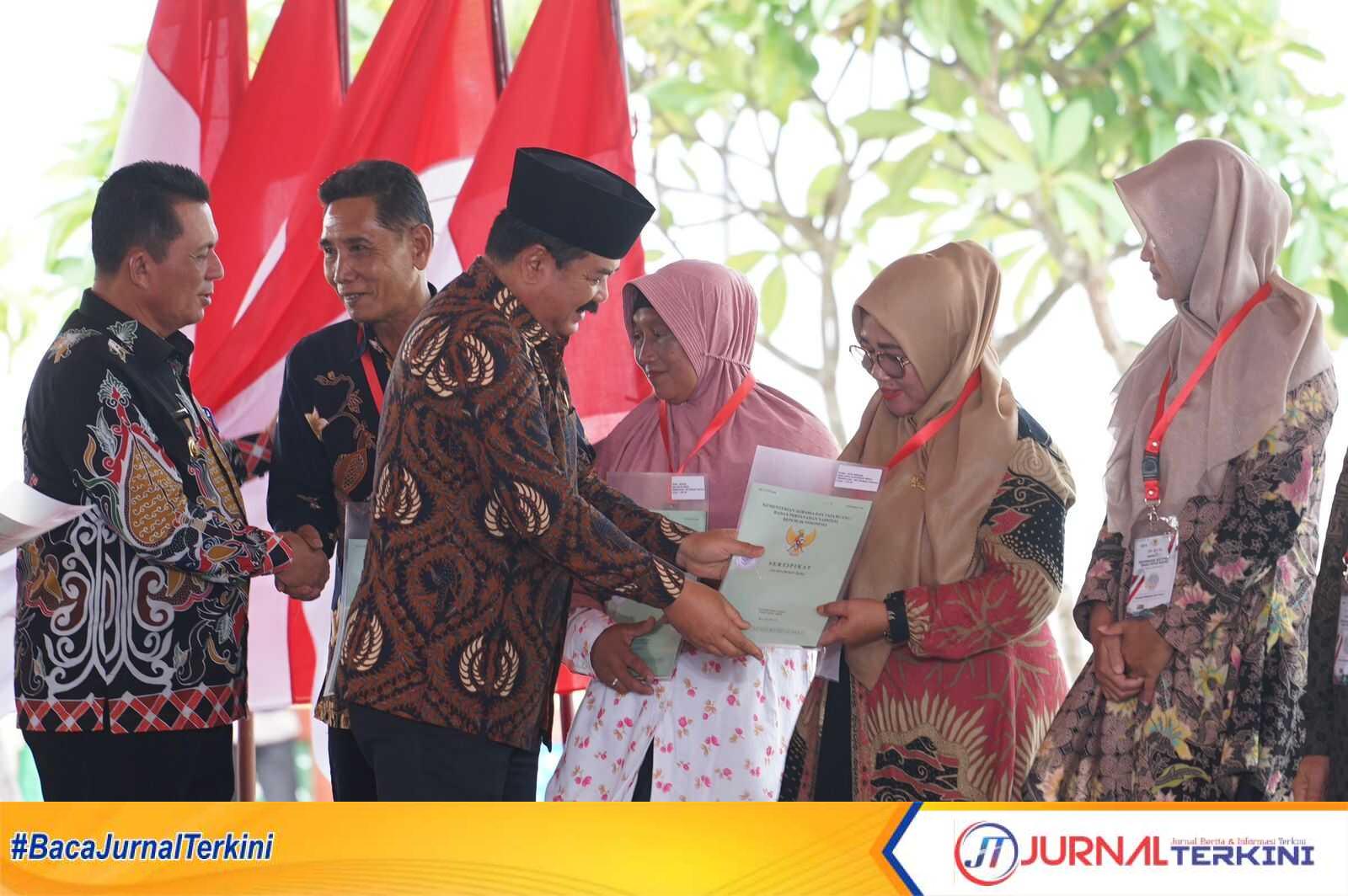 Menteri ATR/BPN Hadi Tjahjanto diikuti Gubernur Kepri Ansar Ahmad menyerahkan sertifikat tanah gratis kepada warga di Coastal Area Karimun, Rabu (30/8/2023). Foto : Eka Perdana (Prokopim Karimun)