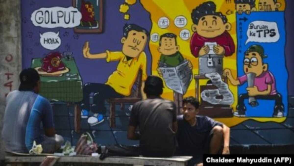 mural kampanye di aceh Orang-orang duduk di depan mural kampanye pemilihan umum di Banda Aceh, Aceh pada 17 Maret 2019. (Foto: Chaideer Mahyuddin/AFP)