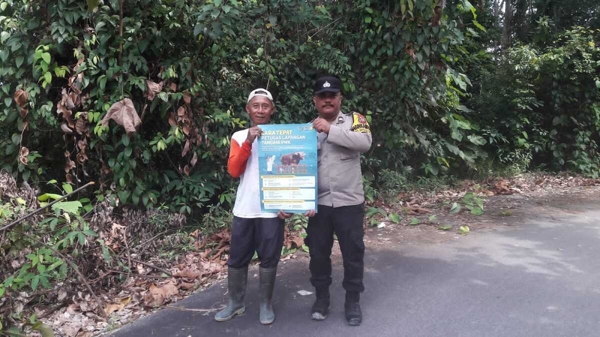 sosialisasi PMK bhabinkamtibmas karimun Bhabinkamtibmas Kelurahan Darussalam, Kecamatan Meral, Aipda Samson Tarigan berpose bersama warga sambil menunjukkan poster imbauan pencegahan penyakit mulut dan kuku (PMK) pada hewan ternak, Selasa (1/8/2023). (Dok. Humas Polres Karimun)