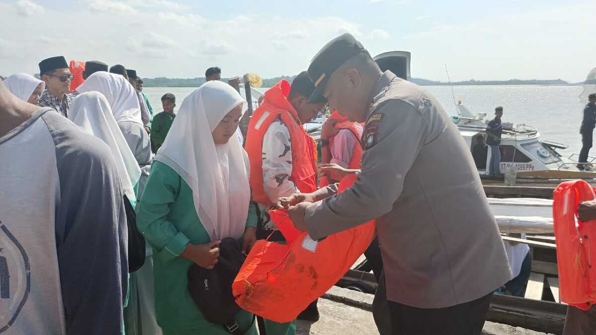 Polsek Buru bagi-bagi life jacket-1 Kapolsek Buru Iptu Junaidi menyerahkan bantuan jaket pelampung atau life jacket kepada siswa di pelabuhan Pangkalan Balai, Kecamatan Buru, Sabtu (9/9/2023). (Dok Humas Polres Karimun)