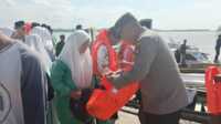 Polsek Buru bagi-bagi life jacket-1 Kapolsek Buru Iptu Junaidi menyerahkan bantuan jaket pelampung atau life jacket kepada siswa di pelabuhan Pangkalan Balai, Kecamatan Buru, Sabtu (9/9/2023). (Dok Humas Polres Karimun)