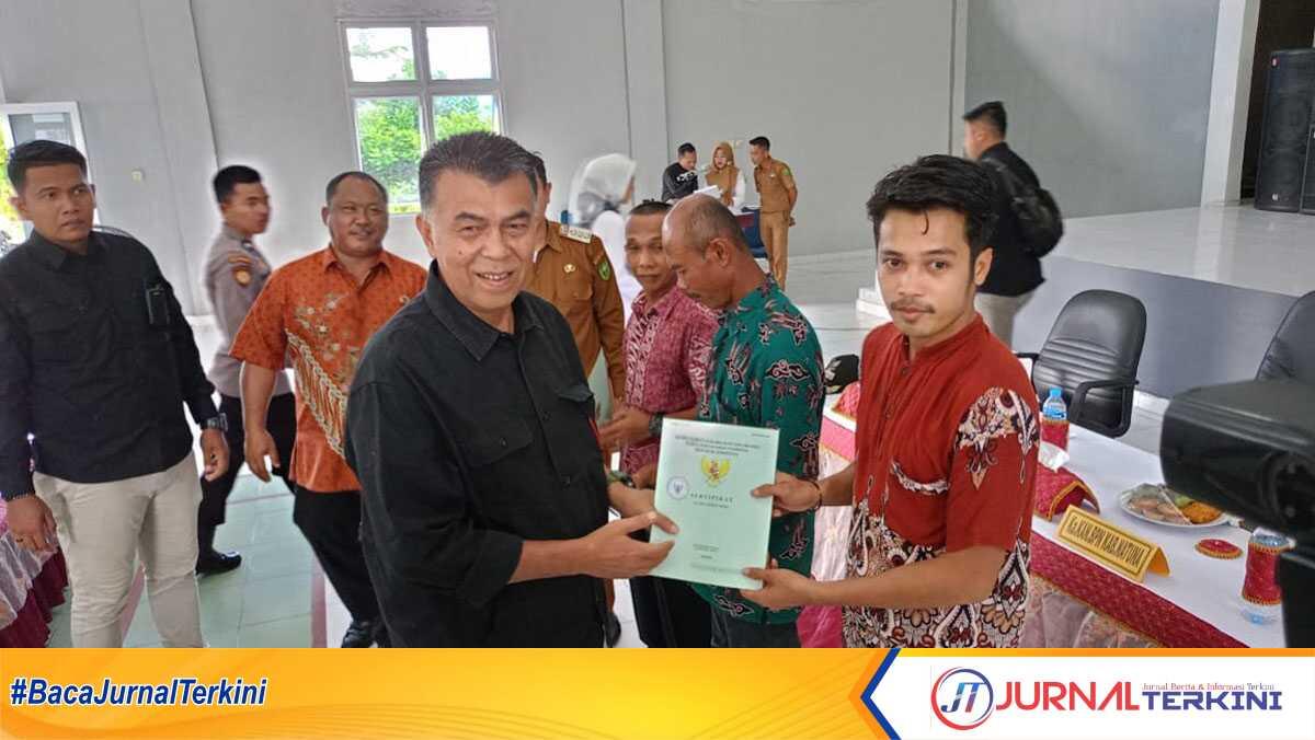 Bupati Natuna, Wan Siswandi saat menyerahkan sertifikat tanah masyarakat Subi di Gedung Serbaguna Kecamatan Subi, Jalan Bukit Lampu, Terayak, Senin, 18 September 2023. (Dokumentasi pribadi)