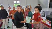 Bupati Natuna, Wan Siswandi saat menyerahkan sertifikat tanah masyarakat Subi di Gedung Serbaguna Kecamatan Subi, Jalan Bukit Lampu, Terayak, Senin, 18 September 2023. (Dokumentasi pribadi)