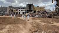 banjir di libya Sejumlah relawan bergerak untuk mencari korban tewas di area yang telah hancur akibat banjir di Libya di Derna, pada 18 September 2023. (Foto: Reuters/Ahmed Elumami)
