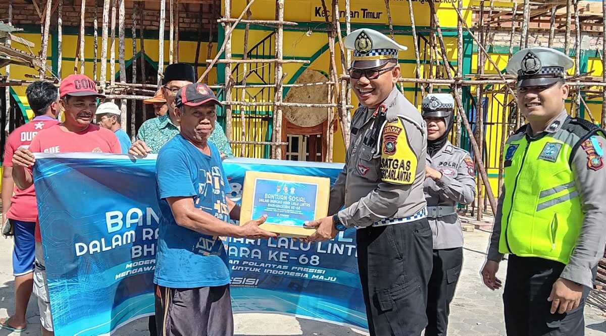 Kasat Lantas Polres Bintan AKP Khafandi menyerahkan bantuan paket sembako kepada buruh bangunan di Bintan dalam rangka HUT Lalulintas ke-68, Jumat (15/9/2023). (Dok. Humas Polres Bintan)