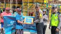 bansos operasi zebra seligi Kasat Lantas Polres Bintan AKP Khafandi menyerahkan bantuan paket sembako kepada buruh bangunan di Bintan dalam rangka HUT Lalulintas ke-68, Jumat (15/9/2023). (Dok. Humas Polres Bintan)