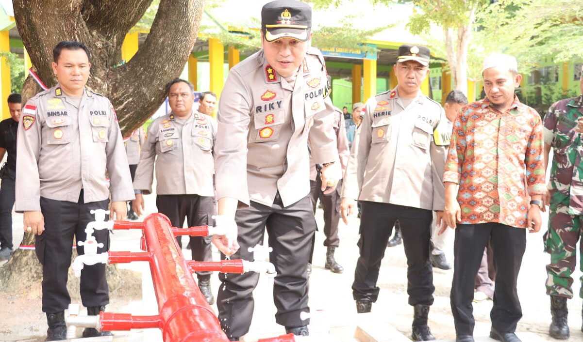 Kapolres Karimun AKBP Ryky W Muharram menjajal aliran air dari sumur bor, bantuan untuk Pondok Pesantren Ar Raudhah di Kecamatan Tebing, Rabu (6/9/2023). (Dok. Humas Polres Karimun)