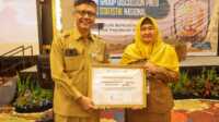 bps award Sekdis Kominfo Prov Kepri James Pattikawa dan Kepala Bidang Statistik dan Persandian Kominfo Kepri Dwi Anggraini memperlihat penghargaan BPS Award 2023 yang digelar di TCC Aston Tanjungpinang, Senin (25/9/2023). (Dok. Diskominfo Kepri)