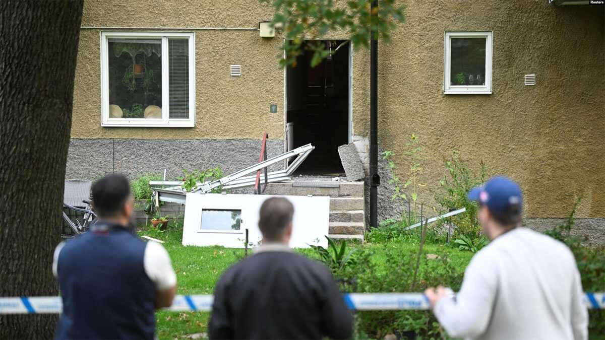 ledakan di swedia Orang-orang mengamati gedung yang ditutup dengan garis polisi menyusul ledakan di Hasselby, Stockholm, Swedia, 26 September 2023. (Fredrik Sandberg/TT News Agency/via REUTERS)