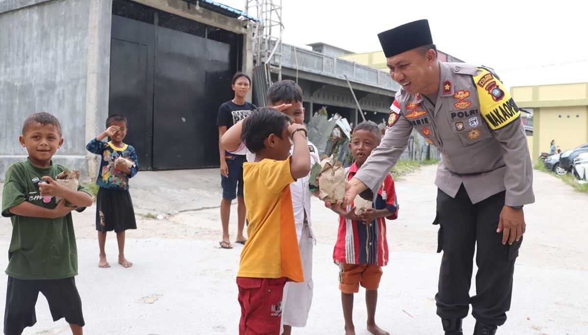 nasi bungkus jumat keliling polres karimun Wakapolres Karimun Kompol Herie Pramono membagikan nasi bungkus kepada salah seorang bocah dalam Jumat Keliling, Jumat (1/9/2023). (Dok. Humas Polres Karimun)
