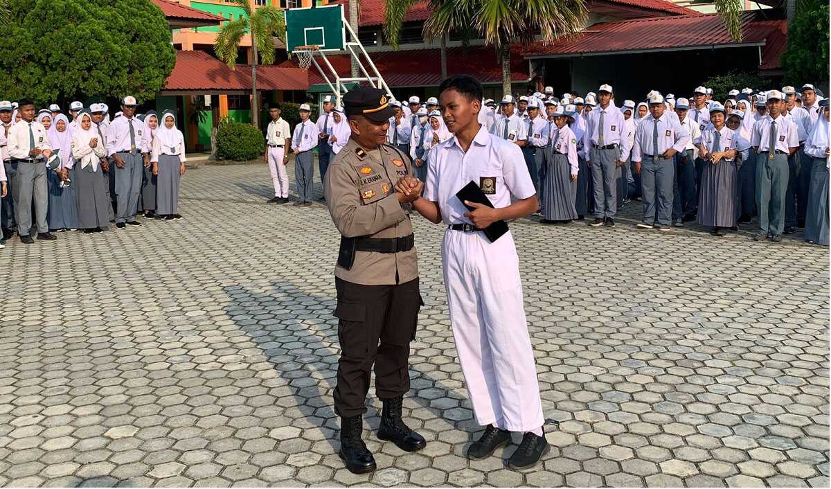KBO Satsamapta Polres Karimun Ipda I Ketua Erawan bersalaman dengan siswa usai menjadi pembina upacara di SMAN 2 Karimun, menyosialisasikan Operasi Zebra Seligi 2023 di SMAN 2 Karimun, Senin (4/9/2023). (Dok Humas Polres Karimun)
