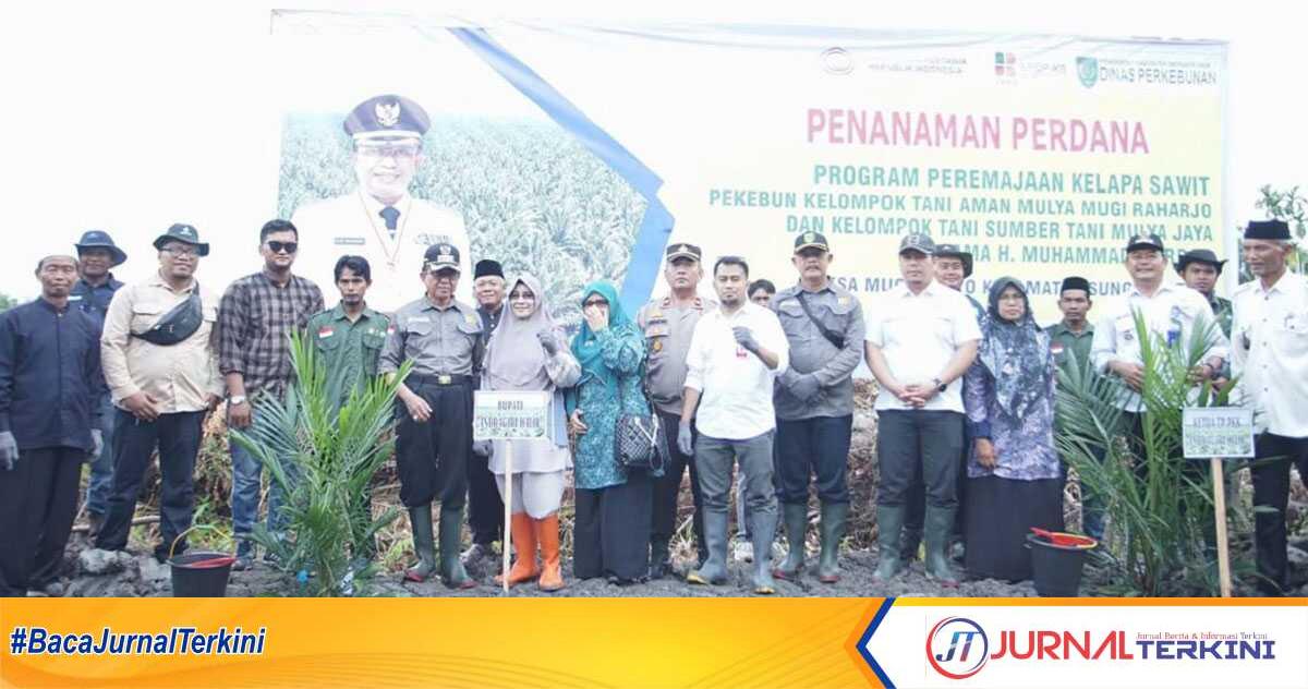 Bupati Inhil HM Wardan (5 kiri) bersama Ketua TP PKK Hj Zulaikhah Wardan, beberapa pejabat berfoto bersama kelompok tani usai penanaman perdana kelapa sawit Prograk PKSP di Desa Mugomulyo, Kecamatan Sungai Batang, Rabu (20/09/2023). (JurnalTerkini.id/Abdullah)