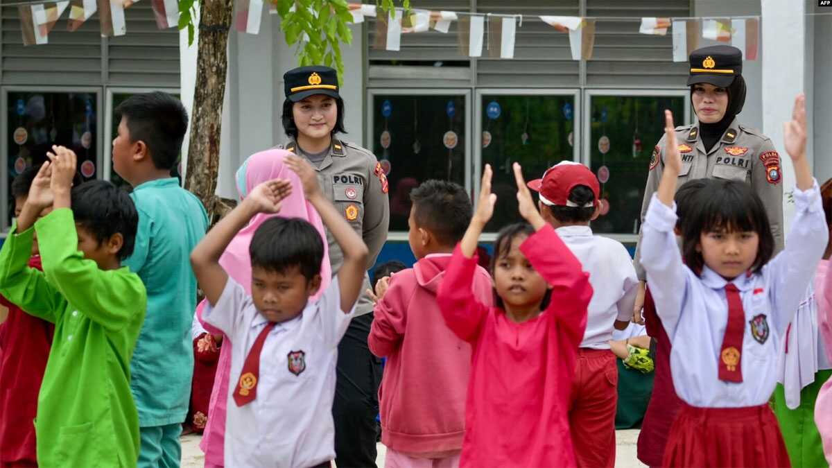trauma healing siswi terimbas ricuh rempang Polisi wanita dari Mapolrestabes Batam bersama siswi SD saat acara "trauma healing" karena banyak siswi yang menolak bersekolah usai bentrok antara warga dan aparat keamanan terkait rencana pemerintah mengembangkan sekolah, 18 September 2023. (Bay ISMOYO/AFP).