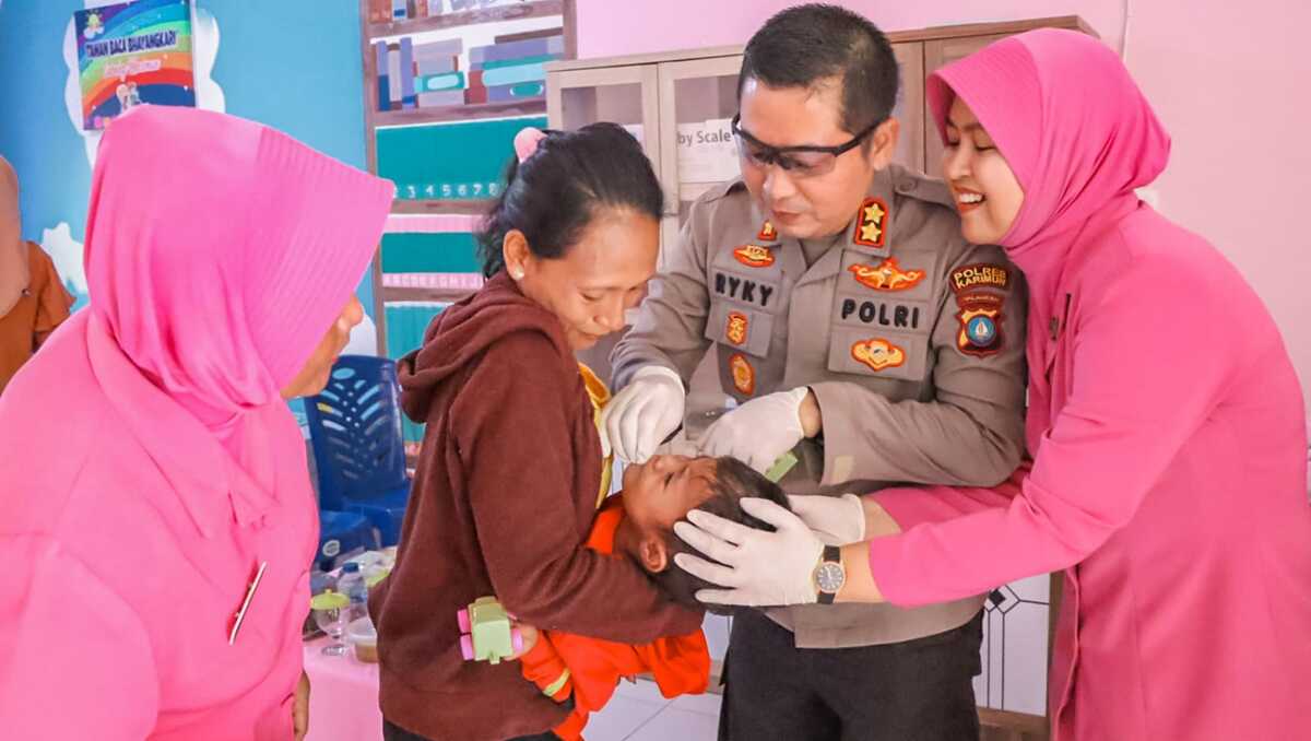 Kapolres Karimun AKBP Ryky W Muharram bersama Ketua Bhayangkari Cabang Karimun Ny Meity Ryky memberikan vitamin A kepada seorang bayi di Posyandu Kemala Asrama Polisi, Kapling, Tanjung Balai Karimun, Jumat (13/10/2023), dalam rangka menyambut Hari Kesatuan Bhayangkari ke-71. (Dok Humas Polres Karimun)