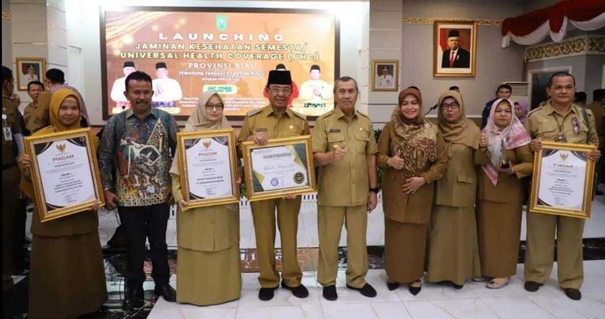 Bupati Inhil H.M.Wardan (4 kiri) menerima penghargaan Jaminan Kesehatan Semesta Universal Health Converage (UHC) dari Gubernur Riau serta Badan Penyelenggara Jaminan Sosial (BPJS) Kesehatan atas komitmennya mencapai UHC Tahun 2023 yang diselenggarakan di Balai Pauh Janggi, Pekanbaru Senin, (16/10/2023). (Bagian Prokopim Setda Inhil)