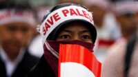 save palestine Seorang perempuan mengenakan ikat kepala bertuliskan "Save Palestine (Selamatkan Palestina" dan memegang bendera merah-putih dalam unjuk rasa memprotes serangan udara Israel di Gaza, Jakarta, 11 Juli 2014. (Foto: Beawiharta/Reuters)