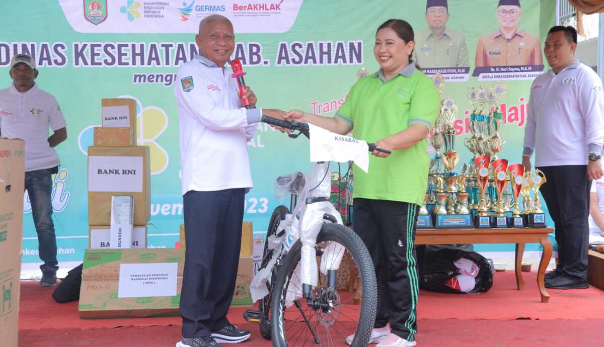 Bupati Asahan Surya menyerahkan hadiah kepada pemenang door prize dalam kegiatan memperingati Hari Kesehatan Nasional ke-59 di Kisaran, Jumat (17/11/2023). (Dok Diskominfo Asahan)