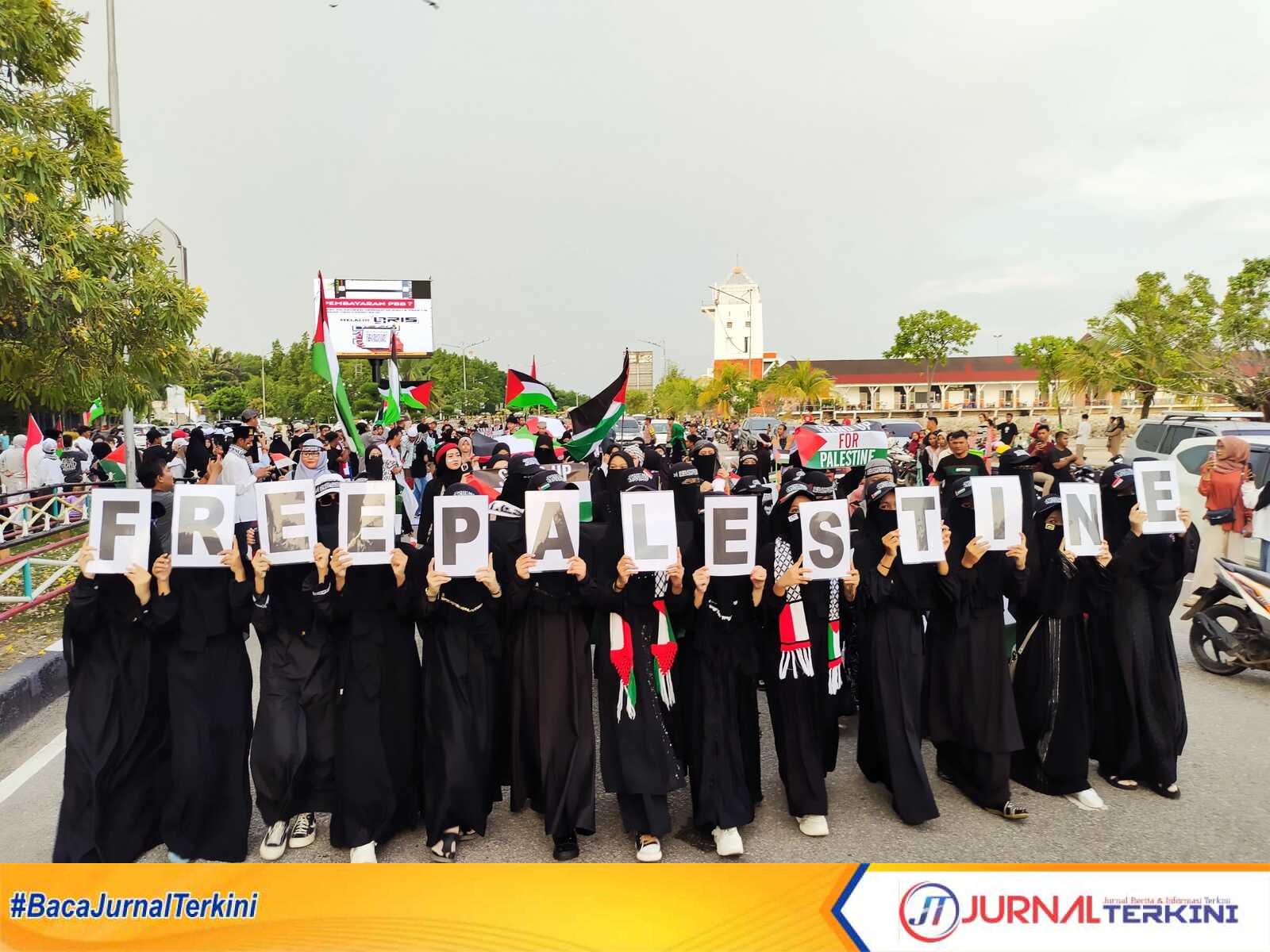 Peserta aksi menunjukkan lembaran kertas berisi huruf yang disatukan menjadi "free palestine" dalam aksi bela Palestina di Coastal Area, Tanjung Balai Karimun, Minggu (12/11/2023). (JurnalTerkini.id/yogi)