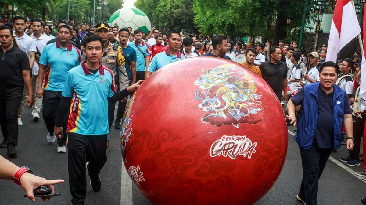 Wali Kota Solo Gibran Rakabuming Raka (kiri) bersama Ketua Umum Persatuan Sepak Bola Seluruh Indonesia Erick Thohir (kanan) dalam acara promosi trofi Piala Dunia U-17 FIFA menjelang turnamen sepak bola remaja di Solo, 5 November 2023. (DEVI RAHMAN/AFP)