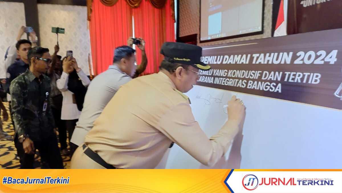 Wakil Bupati Karimun Anwar Hasyim dan Kapolres AKBP Fadli Agus disaksikan Ketua Bawaslu Karimun Muhammad Iskandar membubuhkan tanda tangan deklarasi pemilu damai di ballroom Hotel Aston Karimun City, Tanjung Balai Karimun, Rabu (29/11/2023). (JurnalTerkini.id/jansen)