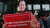Seorang demonstran mengenakan topeng bergambar Ketua KPK Firli Bahuri dalam unjuk rasa di luar kantor Komisi Pemberantasan Korupsi di Jakarta, Jumat 23 November 2023. (Foto: Ajeng Dinar Ulfiana/Reuters)