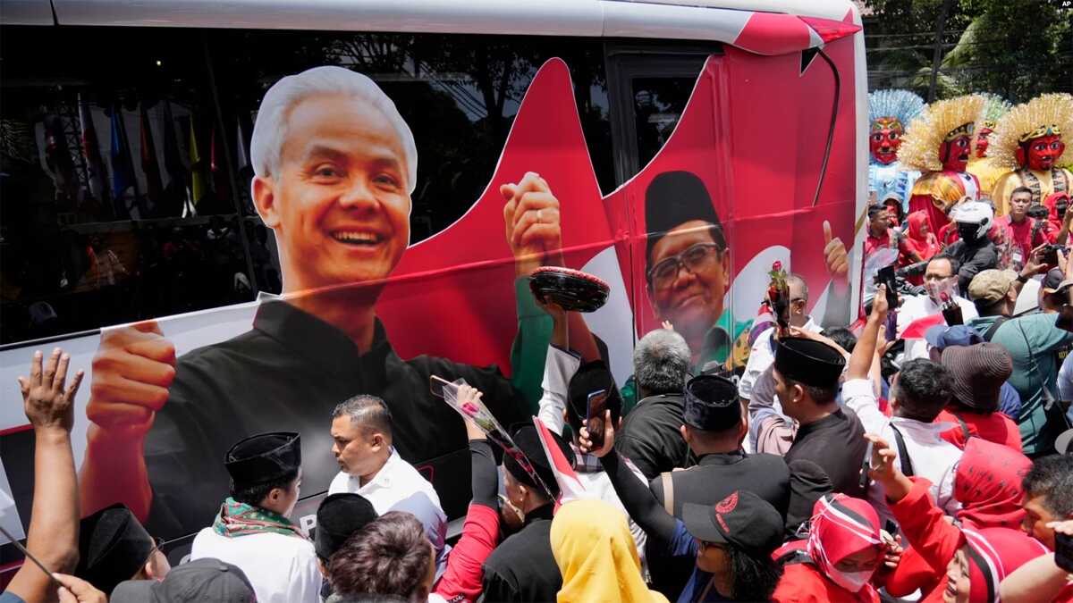 ganjar-mahfud-1 FILE - Para pendukung paslon capres-cawapres Pilpres 2024 Ganjar Pranowo dan Mohammad Mahfud, mengelilingi bus kampanye saat mendaftarkan diri di gedung Komisi Pemilihan Umum di Jakarta, 19 Oktober 2023. (AP/Achmad Ibrahim)