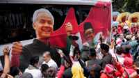 ganjar-mahfud-1 FILE - Para pendukung paslon capres-cawapres Pilpres 2024 Ganjar Pranowo dan Mohammad Mahfud, mengelilingi bus kampanye saat mendaftarkan diri di gedung Komisi Pemilihan Umum di Jakarta, 19 Oktober 2023. (AP/Achmad Ibrahim)