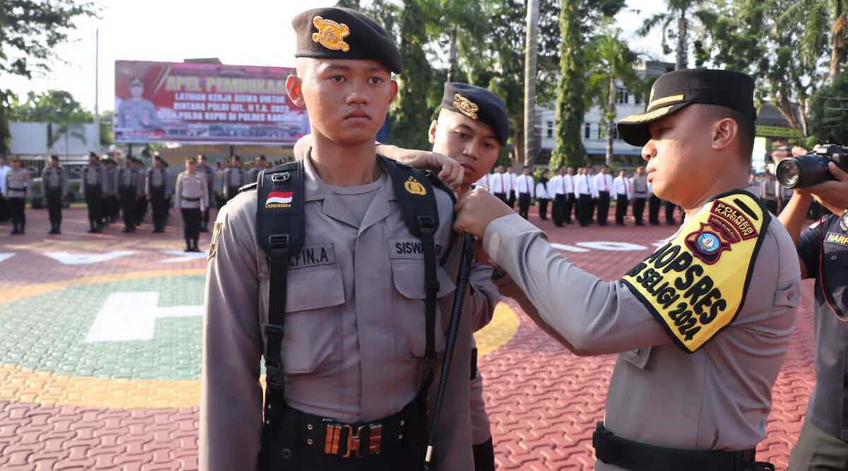 Kapolres Karimun AKBP Fadli Agus menyemeatkan pita kepada salah seorang siswa yang mengikuti latihan kerja (Latja) dalam apel di Mapolres Karimun, Senin (13/11/2023). (Dok Humas Polres Karimun)