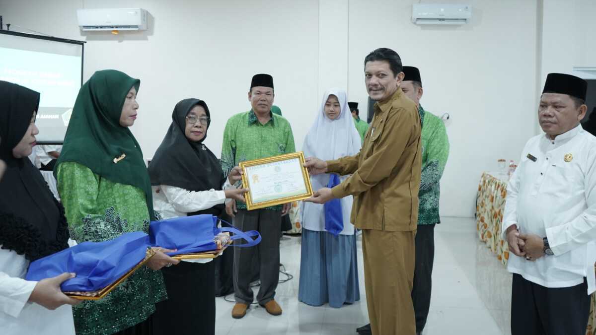 pelantikan perkumpulan guru madrasah asahan Staf Ahli Bupatii Asahan Bidang Hukum dan Politik M. Yusuf Lubis menyerahkan penghargaan di sela pelantikan Perkumpulan Guru Madrasah (PGM) Indonesia Kabupaten Asahan periode 2023 - 2028 di Aula Gedung Zul firman Siregar Universitas Asahan, Senin (13/11/2023). (Dok Diskominfo Asahan)