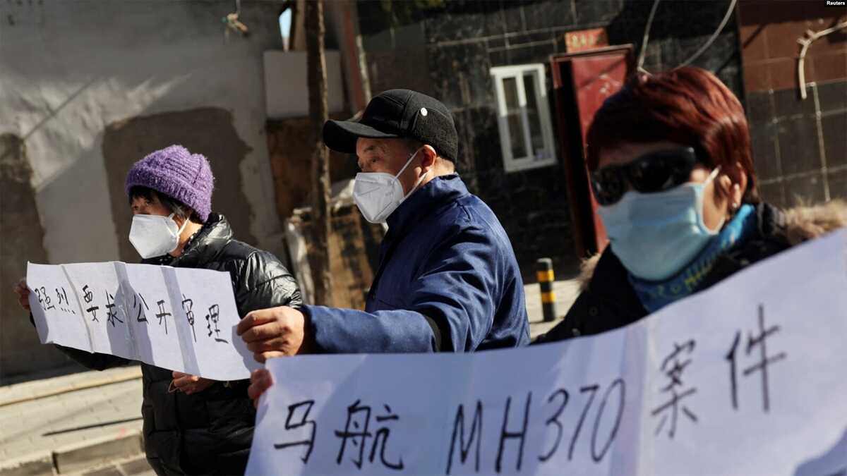 tragedi malaysia airlines Anggota keluarga membawa spanduk saat berbicara kepada media setelah sidang pengadilan tentang kompensasi bagi mereka yang kehilangan orang yang mereka cintai dalam penerbangan Malaysia Airlines MH370 di Beijing, Tiongkok, 27 November 2023. (REUTERS/Florence Lo)