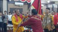 Bupati Karimun Aunur Rafiq menyerahkan pataka kepada Vandarones Purba yang dilantik sebagai Ketua Perkumpulan Karo Merga Silima Kabupaten Karimun (PKMSKK) pEriode 2023-2028 di Gedung Nasional. Rabu (29/11/2023) malam. (JurnalTerkini.id/jansen)