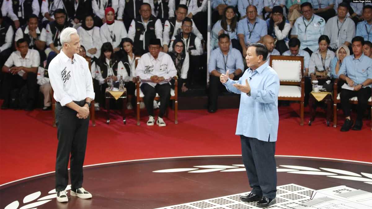 Calon presiden Prabowo Subianto (kanan) menanggapi pertanyaan calon presiden Ganjar Pranowo (kiri) dalam debat pertama Capres 2024 yang diadakan oleh KPU pada Selasa (12/12/2023) di Jakarta. (VOA/Indra Yoga)