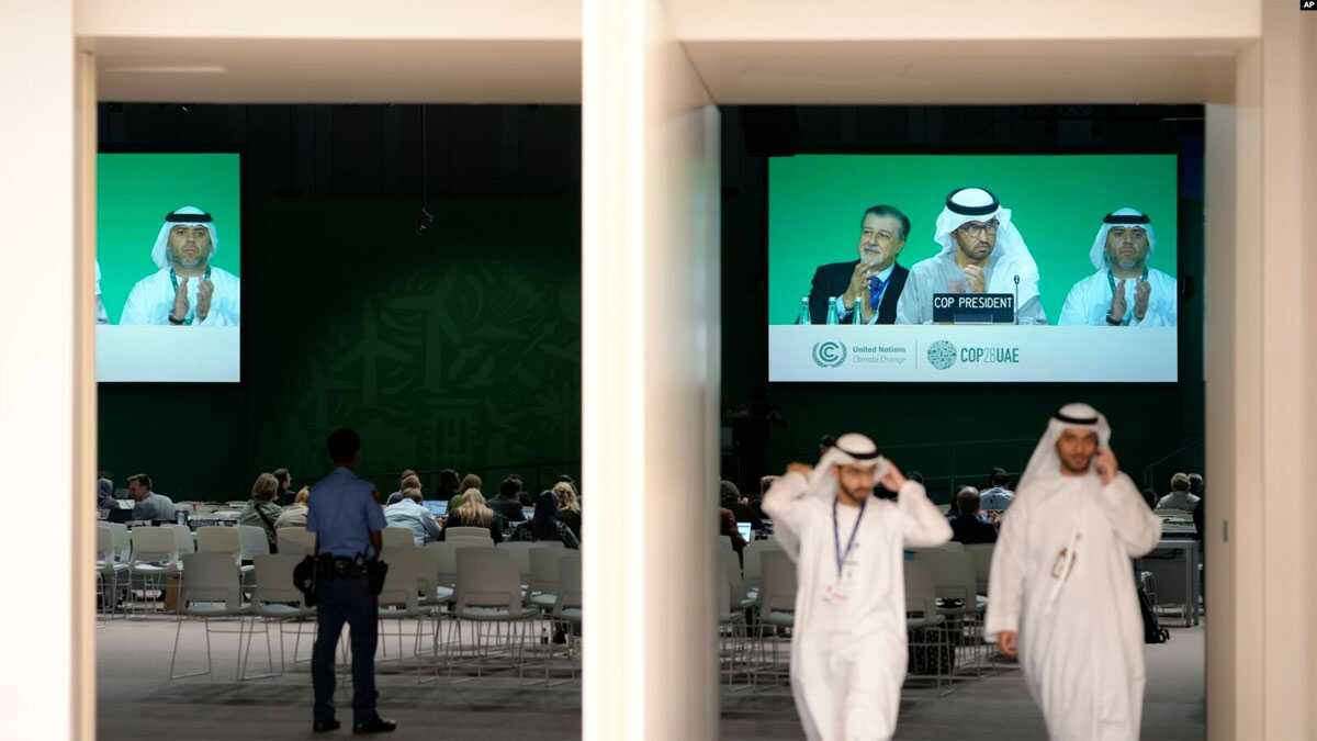CEO COP28 Adnan Amin (kiri), Presiden COP28 Sultan al-Jaber (tengah), dan Direktur Jenderal Duta Besar COP28 Majid Al Suwaidi, bertepuk tangan di layar saat sesi pleno KTT Iklim PBB COP28, di Dubai, Uni Emirat Arab, Rabu, 13 Desember 2023. (AP/Peter Dejong)