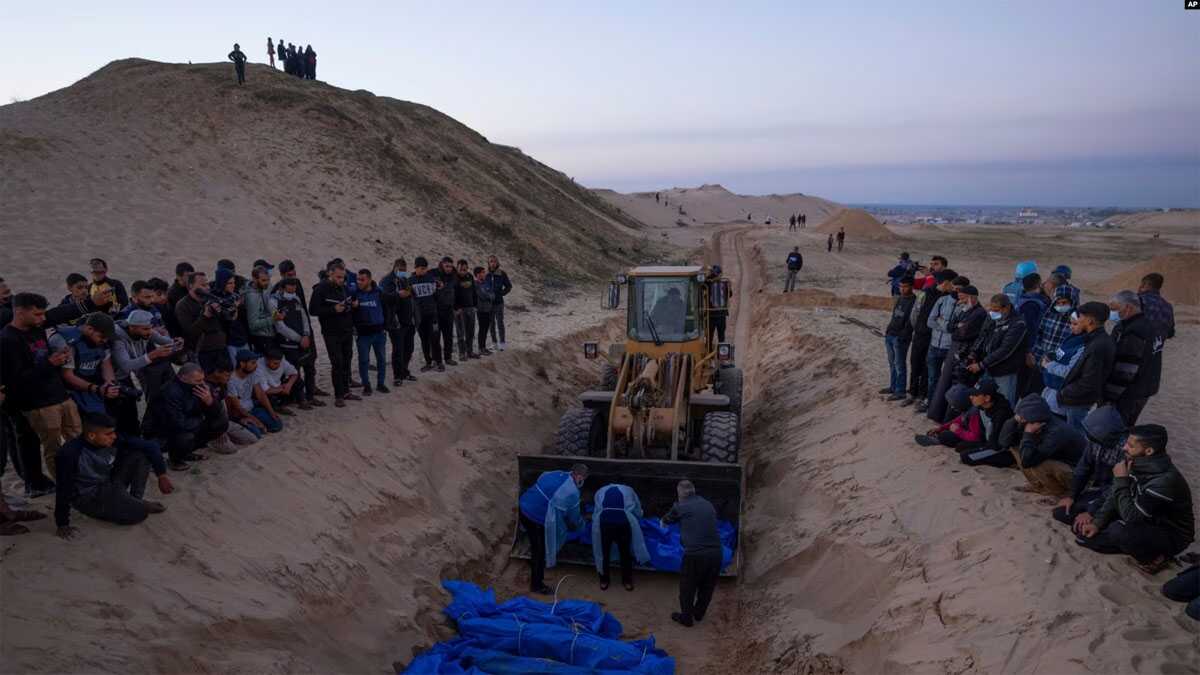pejabat senior hamas Buldoser membawa sejumlah jenazah warga Palestina yang tewas dalam operasi militer Israel dalam pemakaman massal di Rafah, Jalur Gaza, pada 26 Desember 2023. (Foto: AP/Fatima Shbair)