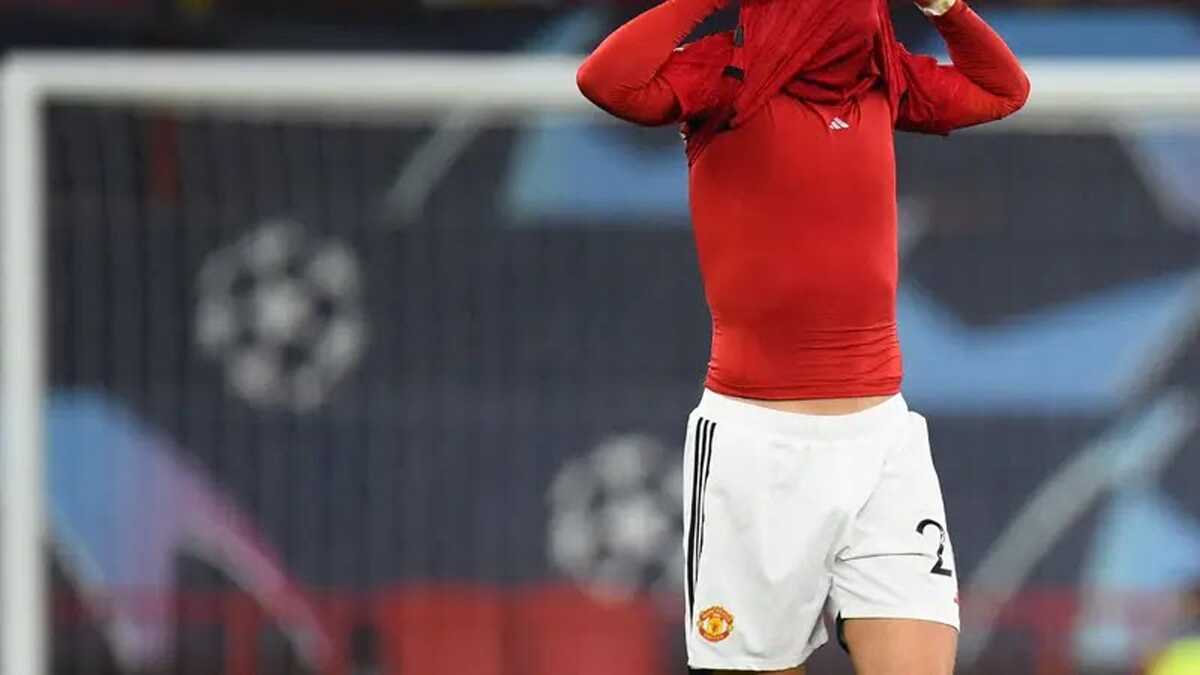 Pemain Manchester United (MU), Diogo Dalot, menutupi wajahnya dengan kostum setelah kalah dari Bayern Munchen pada laga matchday keenam Liga Champions 2023/2024, Rabu (13/12/2023) dini hari WIB. (Peter Powell/AFP)