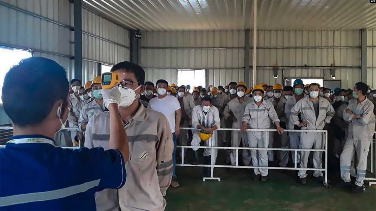Petugas kesehatan memeriksa suhu tubuh pekerja PT Indonesia Morowali Industrial Park di Morowali, Sulawesi Tengah. BRIN mengatakan pekerja dari Tiongkok mendominasi jumlah pekerja asing di Tanah Air yang mencapai 44,49 persen dari total pekerja asing. (Foto: AFP)