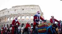 santa di roma Sejumlah warga berdandan menjadi sinterklas dan bersepeda keliling Roma untuk menggalang dana untuk kegiatan amal pada 17 Desember 2023. (Foto: Reuters/Guglielmo Mangiapane)