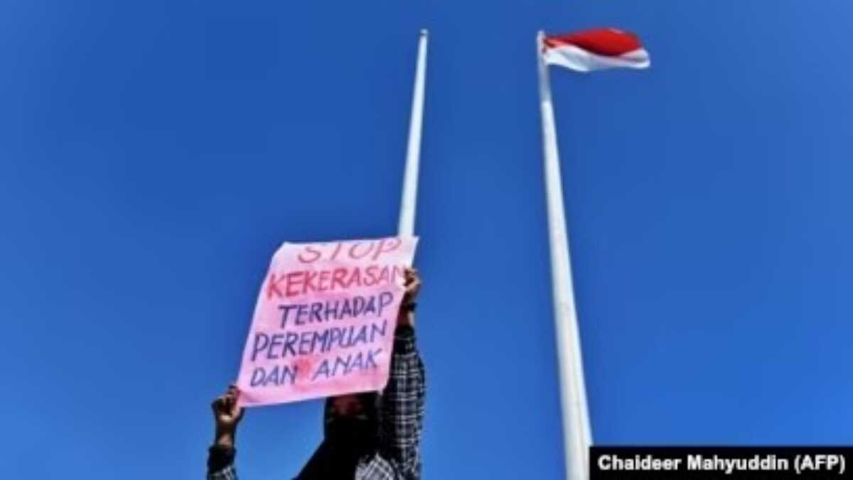 Seorang pedemo menunjukkan poster bertulikan stop kekerasan terhadap perempuan di DPR Aceh, Banda Aceh, 23 Desember, 2023. (Foto: Chaideer Mahyuddin/AFP)