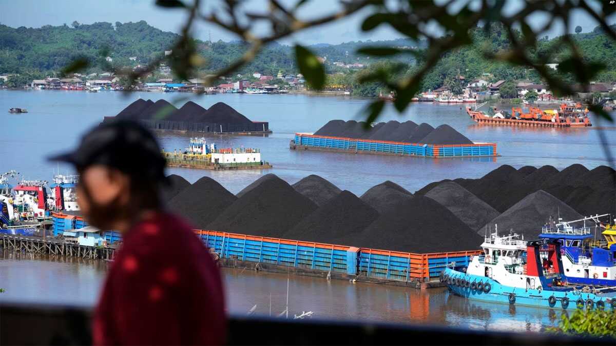 Tongkang batu bara berlabuh di Sungai Mahakam di Samarinda, Kalimantan Timur, Senin, 19 Desember 2022. (AP/Dita Alangkara)