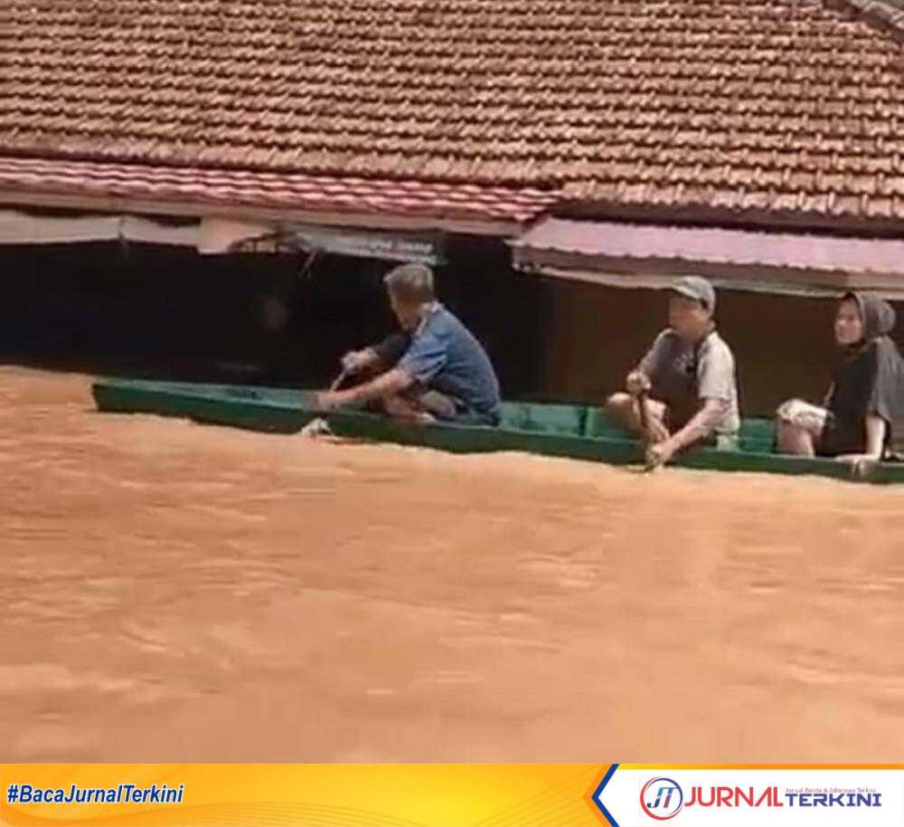 Warga naik sampah di tengah banjir yang melanda Kabupaten Muratara, Provinsi Sumatera Selatan. Banjir akibat luapan air Sungai Rupit dan Sungai Ulu Rawas, Kamis (11/1/2023). (jurnalterkini.id/alam budi kesuma)