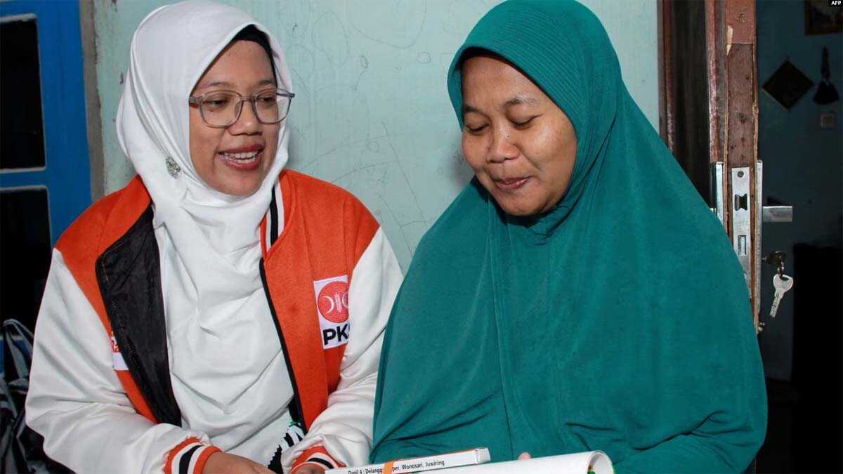 Lingga Permesti (kiri) caleg dari Partai Keadilan Sejahtera (PKS) mengunjungi salah satu rumah warga di Klaten, Jawa Tengah, pada 18 Januari 2024. (Foto: AFP/Agung Nugroho)