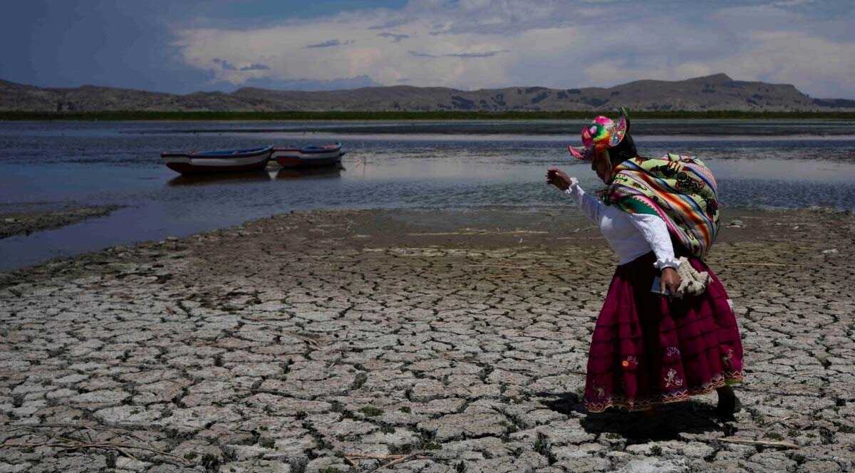 FILE - Maruja Inquilla berjalan di bagian Danau Titicaca yang kering di Coata, Peru, Rabu, 29 November 2023, di tengah gelombang panas. (AP/Martin Mejia)