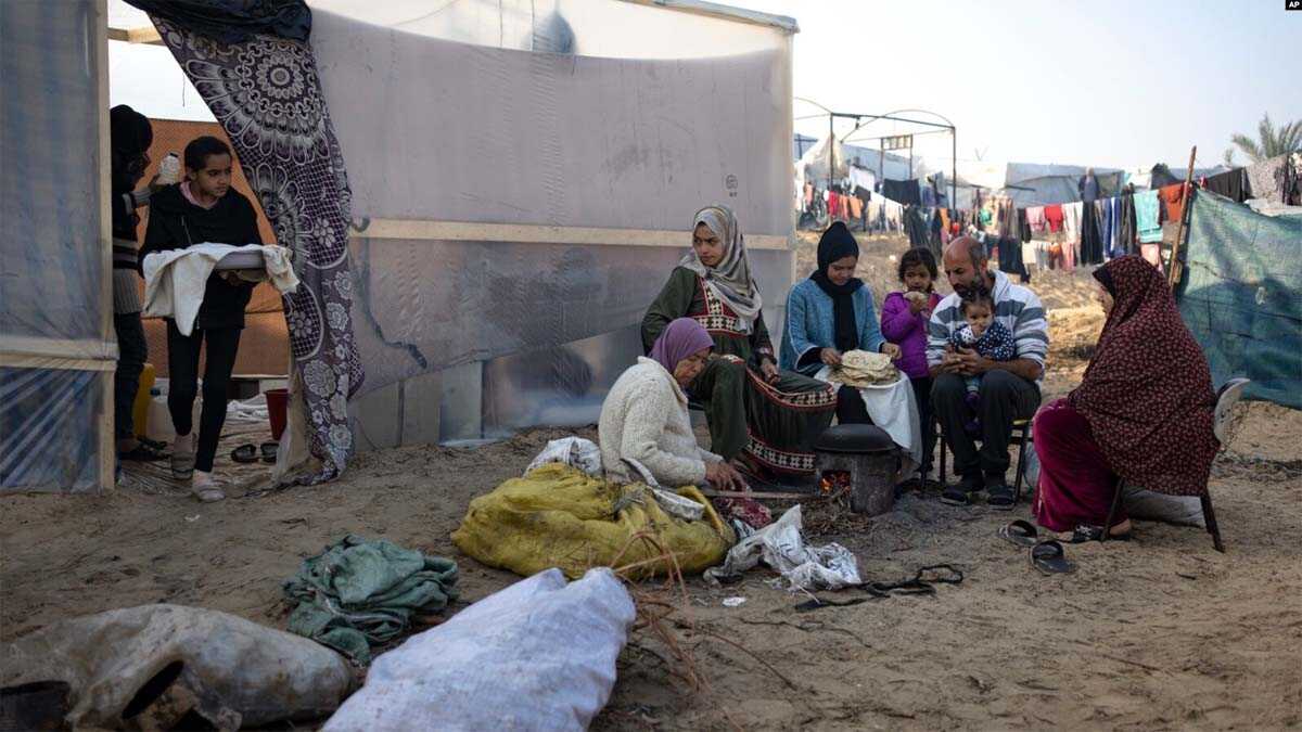 pengungsi gaza Anggota keluarga Abu Jarad, yang mengungsi akibat pemboman Israel di Jalur Gaza, memanggang roti di tenda kamp darurat di daerah Muwasi, Gaza selatan.