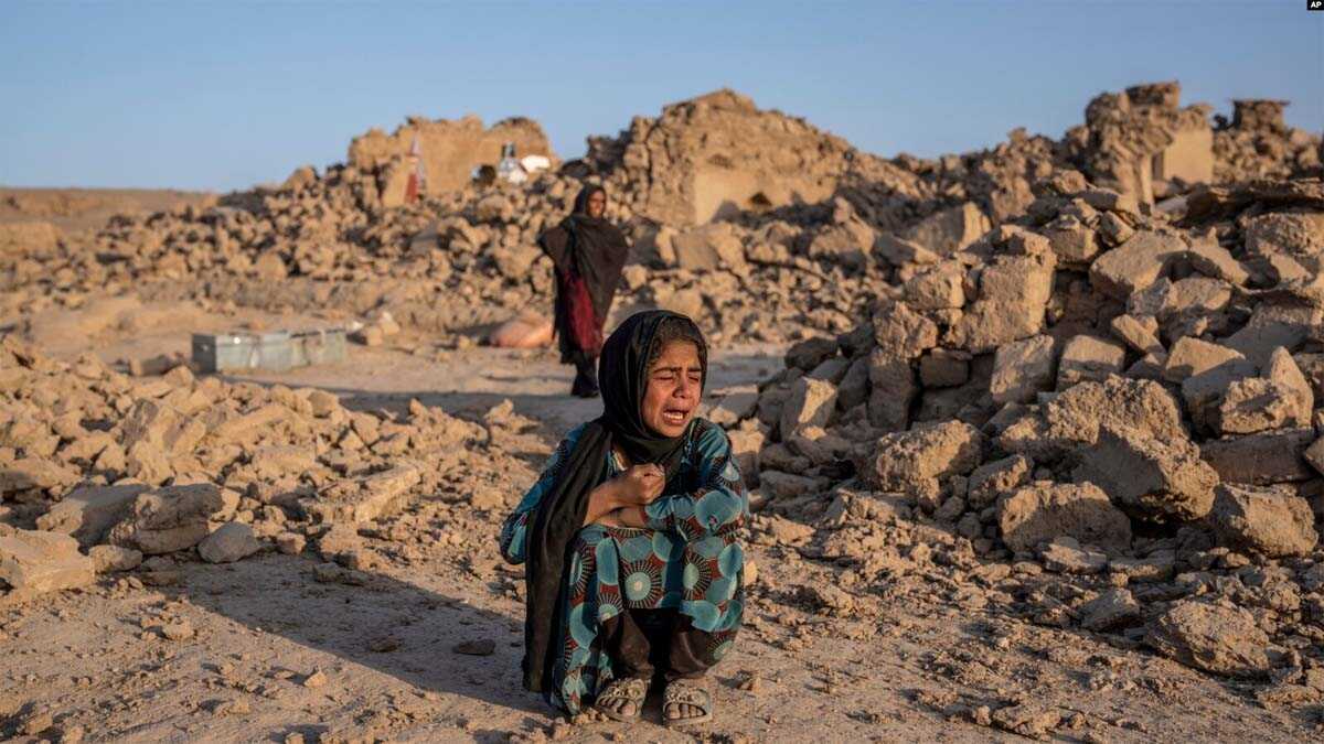 FILE- Seorang anak perempuan Afghanistan menangis di depan rumahnya yang hancur akibat gempa bumi di distrik Zenda Jan di provinsi Herat, Afghanistan barat, 11 Oktober 2023. (AP/Ebrahim Noroozi)