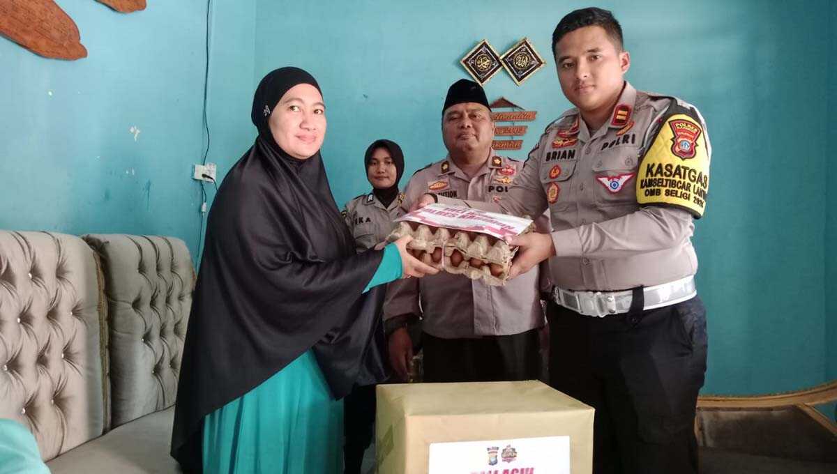 Kabaglog Polres Karimun Kompol BT Nasution didampingi Kasat Lantas Iptu Dristica Brian AL memerikan bingkisan kepada warakawuri, Fitri Yulian di Tanjung Balai Karimun, Jumat (5/1/2024). (Dok Humas Polres Karimun)