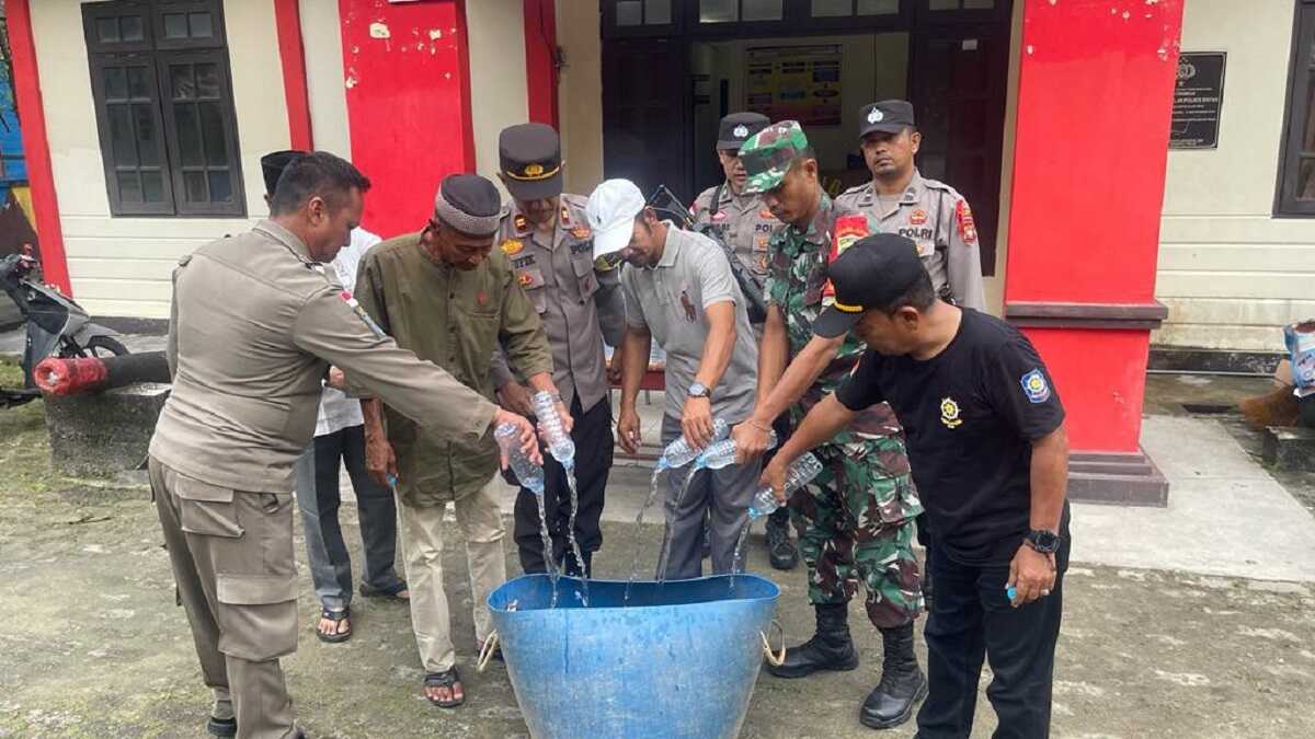 Polsek Tambelan memusnahkan ratusan botol miras jenis arak yang ditemukan di atas kapal roro KMP Nusantara 3 di Pelabuhan Tambelan, Kabupaten Bintan, Selasa (2/1/2024). (Dok Polsek Tambelan)