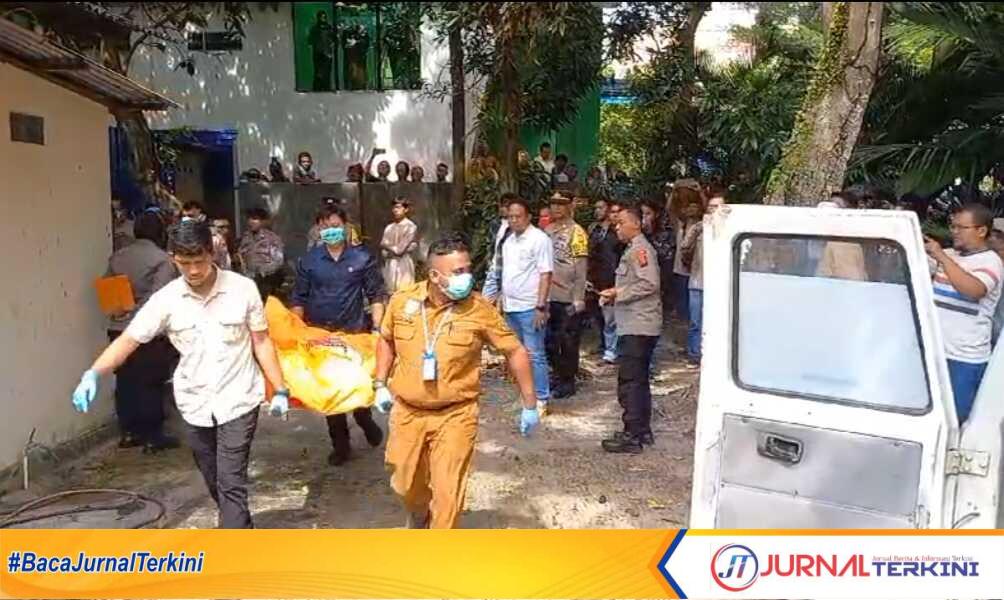 Petugas medis dan aparat kepolisian mengangkat jenazah Hendry Sastria yang ditemukan tergantung di sebuah rumah di Jalan Kartini, Kelurahan Tanjung Balai Kota, Selasa, 6 Februari 2024. (jurnalterkini.id/yogi)