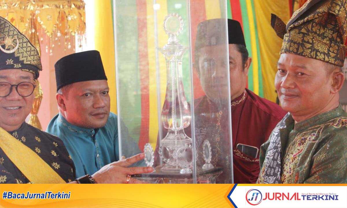 Sekretaris Daerah (Sekda) Kabupaten Karimun Muhammmad Firmansyah (kiri) menyerahkan piala bergilir MTQ tingkat Kecamatan Meral Barat di Kelurahan Darussalam, Senin (19/2/2024). (jurnalterkini.id/yogi)