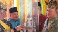 Sekretaris Daerah (Sekda) Kabupaten Karimun Muhammmad Firmansyah (kiri) menyerahkan piala bergilir MTQ tingkat Kecamatan Meral Barat di Kelurahan Darussalam, Senin (19/2/2024). (jurnalterkini.id/yogi)