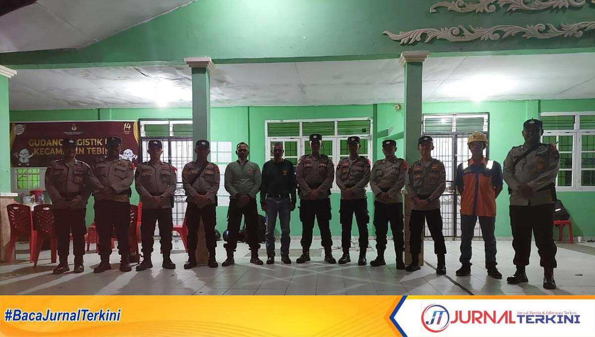 Petugas kepolisian, TNI, Linmas dan Satpol PP berjaga di pintu masuk gudang logistik Panitia Pemilihan Kecamatan (PPK) Tebing, Kamis (15/2/2024). (jurnalterkini.id/jansen)